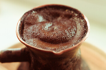 Natural coffee with thick foam, brewed in a copper cezve in the classical way, on a wooden...