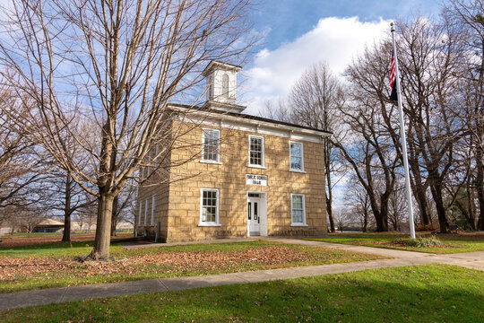 Old unused/abandoned sandstone two story schoolhoise in the afternoon light.  Adeline, Illinois, USA.