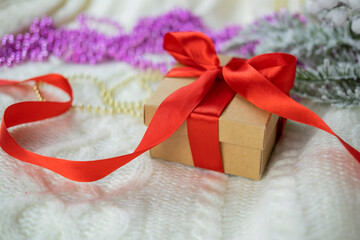 
beautiful festive surprise gift box with a red bow on a bokeh background and near the Christmas tree for new year and valentine's day