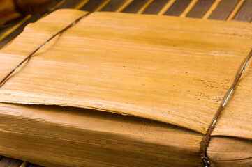 Chinese pressed PU-erh tea in bamboo leaf packaging on a bamboo Mat, close-up, macro