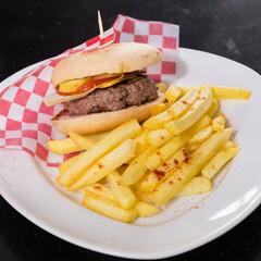 Plate with a tasty hamburger and French fries.