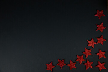 Fototapeta na wymiar Christmas background Layflat. Red stars on black background, christmas decor, flatlay. Place for text, snow