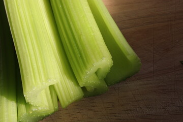 sticks of celery on wooden chopping board