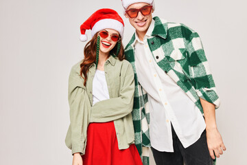 Cheerful young couple wearing black glasses for Christmas holiday close-up hug