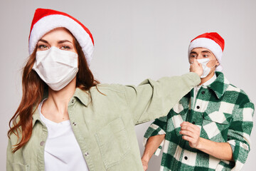 Man and woman in medical masks Christmas hats holiday Friendship close-up