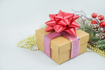 surprise gift box with a pink bow with a decor on the background of a Christmas tree branch for the New Year and Valentine's Day
