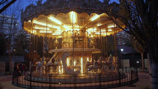 Illuminated carousel at night in an amusement park 4k