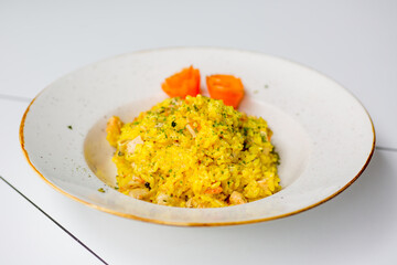 Asty rice pilaf with vegetables isolated on white table.