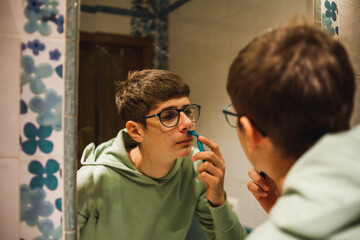 young teenager shaving in the bathroom