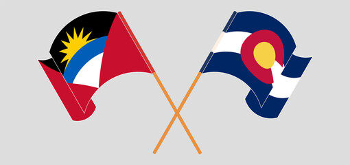 Crossed and waving flags of Antigua and Barbuda and The State of Colorado