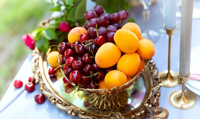 Still life, fresh fruits and berries on the festive table. Wedding rings, engagement