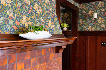 Interior Architectural wood, tile and wall paper details on fireplace with mantel in craftsman residential home.
