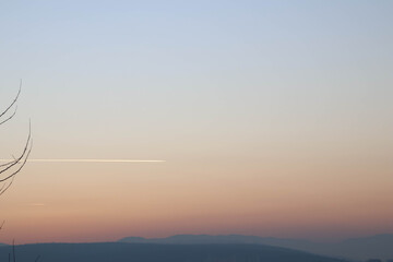 A beautiful trace of plane on a sky in gradient during sunset.