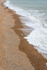 Waves from the English channel sea gently glide to and fro across the famous pebbled beach,during the late winter,Brighton,East Sussex,England,United Kingdom.