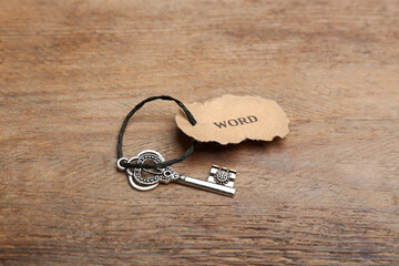 Vintage key with tag on wooden table. Keyword concept