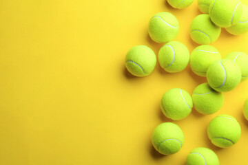 Tennis balls on yellow background, flat lay. Space for text