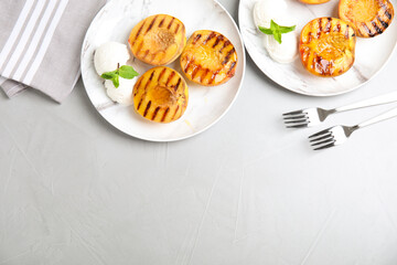 Delicious grilled peaches with ice cream and honey on grey table, flat lay. Space for text