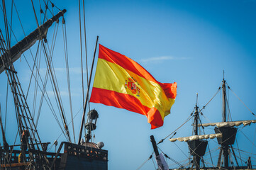 bandera española ondeante al viento en un galeón español - obrazy, fototapety, plakaty
