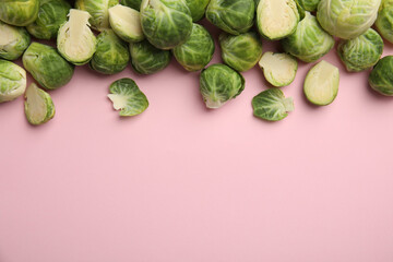 Fresh Brussels sprouts on pink background, flat lay. Space for text