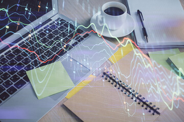 Multi exposure of forex graph drawing and desktop with coffee and items on table background. Concept of financial market trading