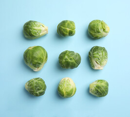 Fototapeta premium Fresh Brussels sprouts on light blue background, flat lay