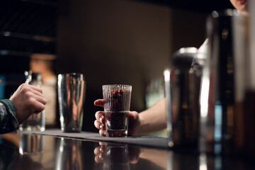 glass with flower buds for decorating cocktails on the bar close up.