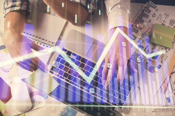 Double exposure of man and woman working together and forex graph hologram drawing. Financial...