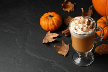 Delicious pumpkin latte on black slate table. Space for text