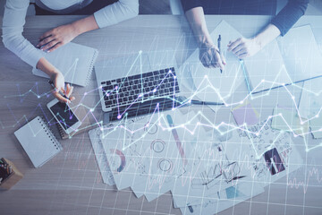 Double exposure of woman hands working on computer and forex graph hologram drawing. Top View....
