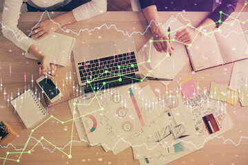 Double exposure of woman hands working on computer and forex graph hologram drawing. Top View. Financial analysis concept.