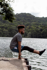 Fototapeta premium young man stretching on the shore of a lake