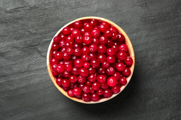 Tasty ripe cranberries on black table, top view