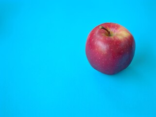 Red apple on blue background
