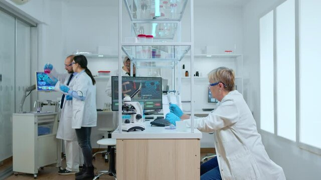 Timelapse of medical team working in modern equipped reasearch center. Multiethnic scientists examining vaccine evolution using high tech for research in treatment development against covid19 virus