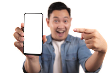 Portrait of young young Asian man presenting smart phone mockup with happy cheerful expression