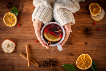 German tradition winter Christmas market new year holidays festival drink tea punch Gluhwein Mulled hot warm red Wine in apple orange mug spices citrus aromatic cinnamon star anise woman hand hold