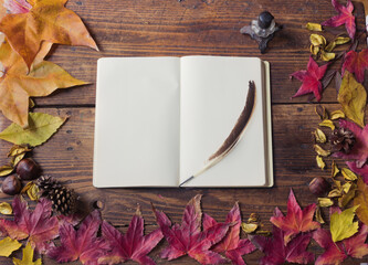 Blank book, with ink pen and inkwell, autumn still life with yellow and red leaves