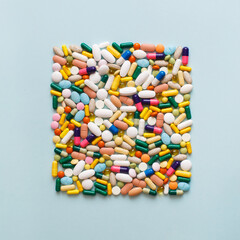 Creative layout of colorful pills and capsules on blue background. Minimal medical concept....