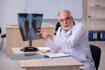 Old male doctor radiologist working in the clinic