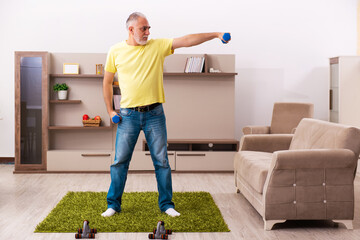 Aged man doing sport exercises at home