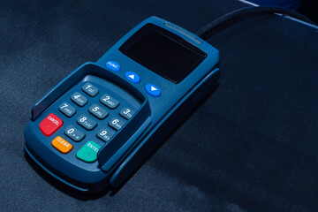 Close-up of the POS terminal. Cashless payment for goods and services. Payment device on a dark background. Payments using Bank cards.
