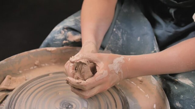 Hands of crafts-artist making craft, pottery, sculptor from fresh wet clay on pottery wheel, Modeling of pottery on the potter's wheel