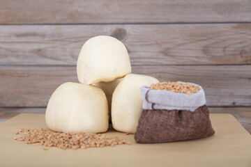 White flour buns and a bag of wheat and scattered wheat