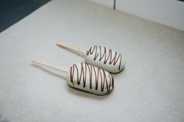 delicious cake like ice cream on a stick in icing and chocolate on a napkin