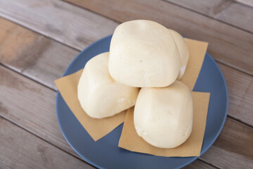 A pile of freshly made big white steamed buns on a plate