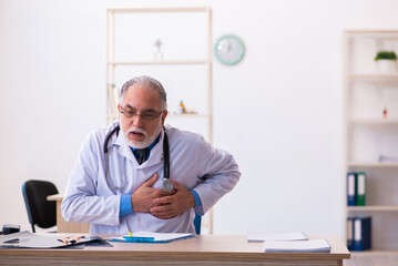 Old male doctor working in the clinic