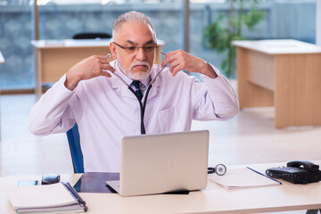 Old male doctor working in the clinic