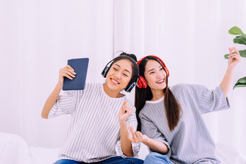 Beautiful asian lesbian couple listening to music together at home,LGBT concept