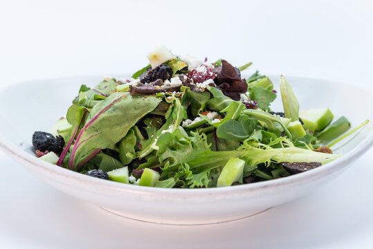 Large Bowl Of Salad Topped With Prunes And Croutons