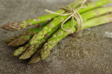 Bunches of green asparagus on a gray background. Closeup